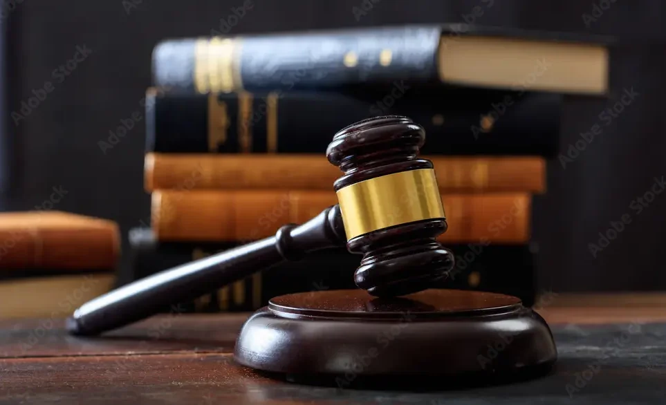 Image of Judicial Court Gavel with Books Stacked in Background.